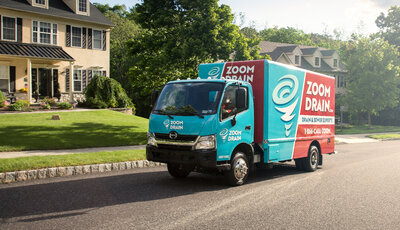 Zoom Drain work truck driving on residential street